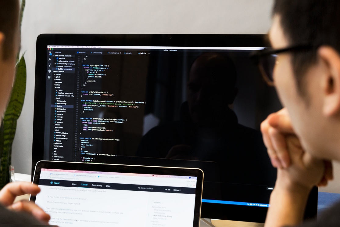 Website developers doing software development and looking at website code